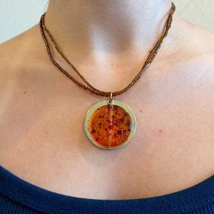 Brown choker necklace with orange and gold pendant